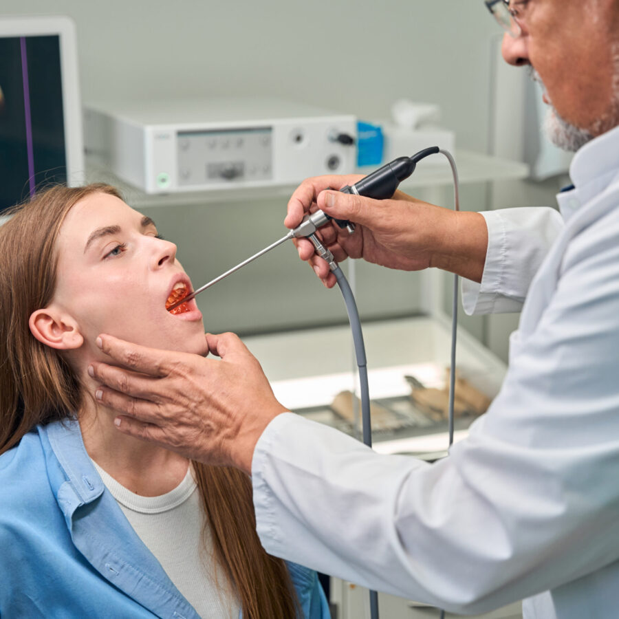 Medical professional carefully examines the patients throat using a specialized medical tool in a clinic setting
