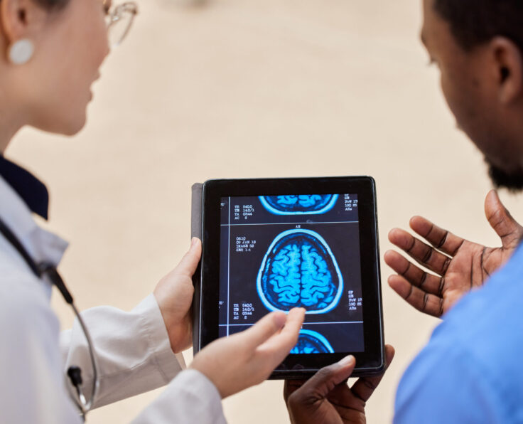 Tablet, cancer or x ray of the brain with a doctor and nurse talking in a hospital for diagnosis cl.