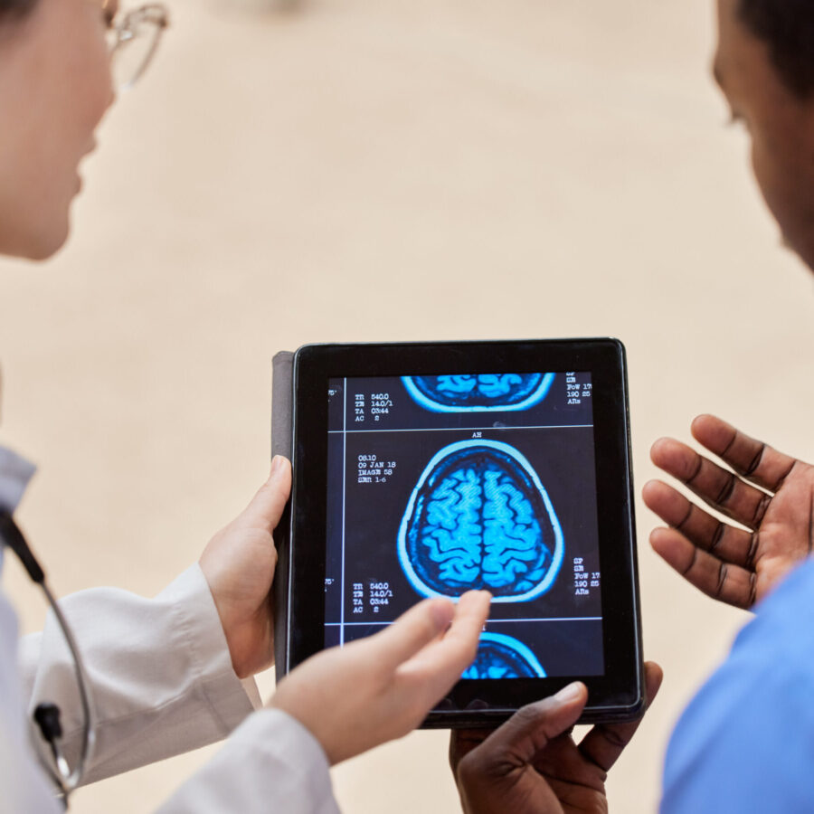 Tablet, cancer or x ray of the brain with a doctor and nurse talking in a hospital for diagnosis cl.
